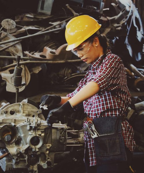 pexels-photo-1108101-1108101 Woman engineer wearing safety gear, working on machine repair in an industrial setting.